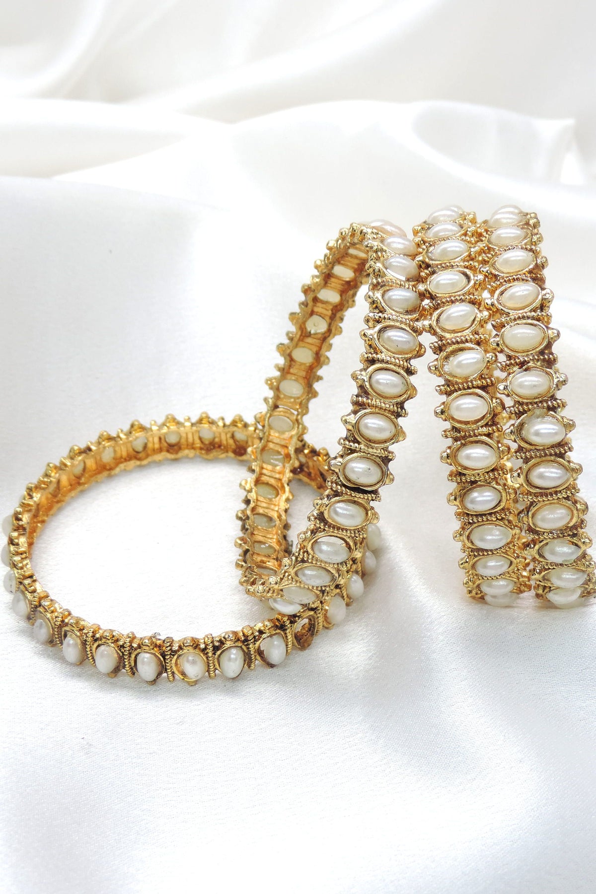 Gold-toned polki white pearl bangle set with intricate detailing by joyrias