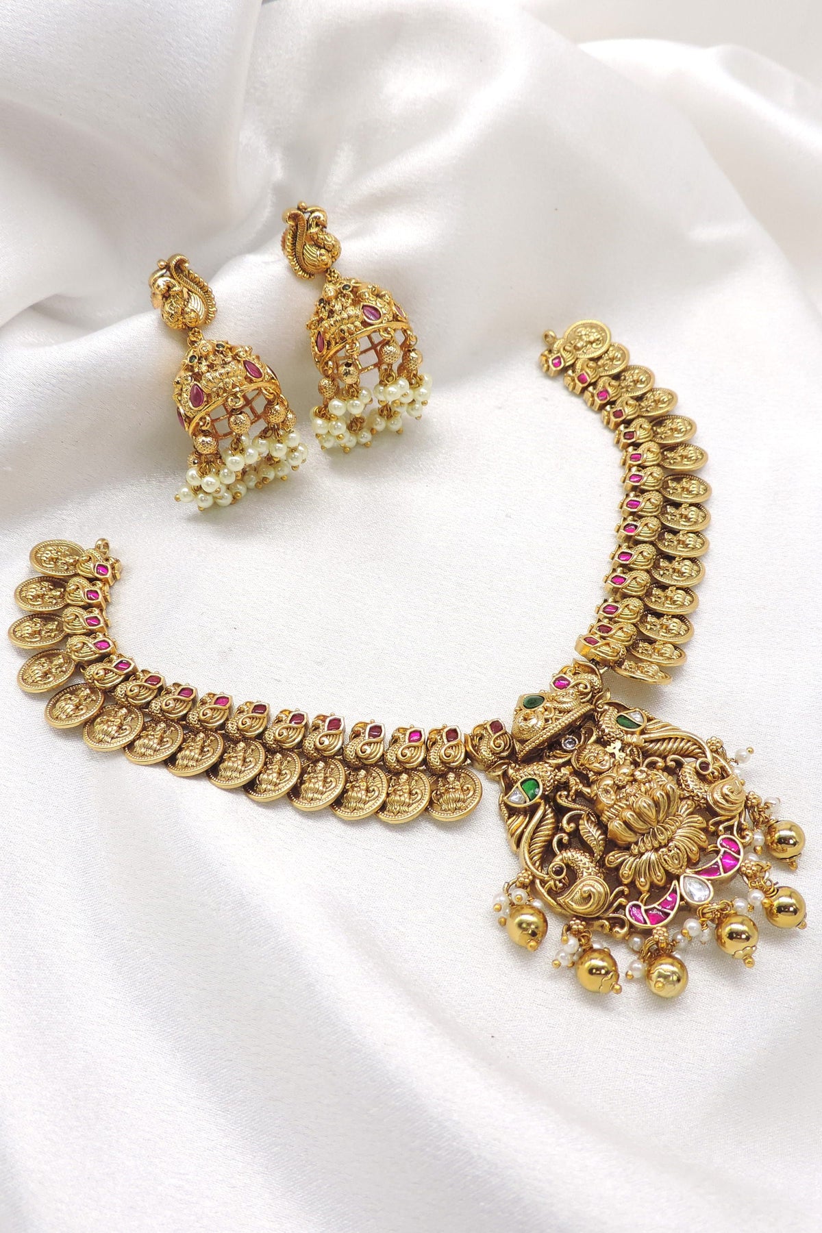 Ruby emerald gold plated temple necklace set with intricate coin motifs and jhumka earrings by joyrias