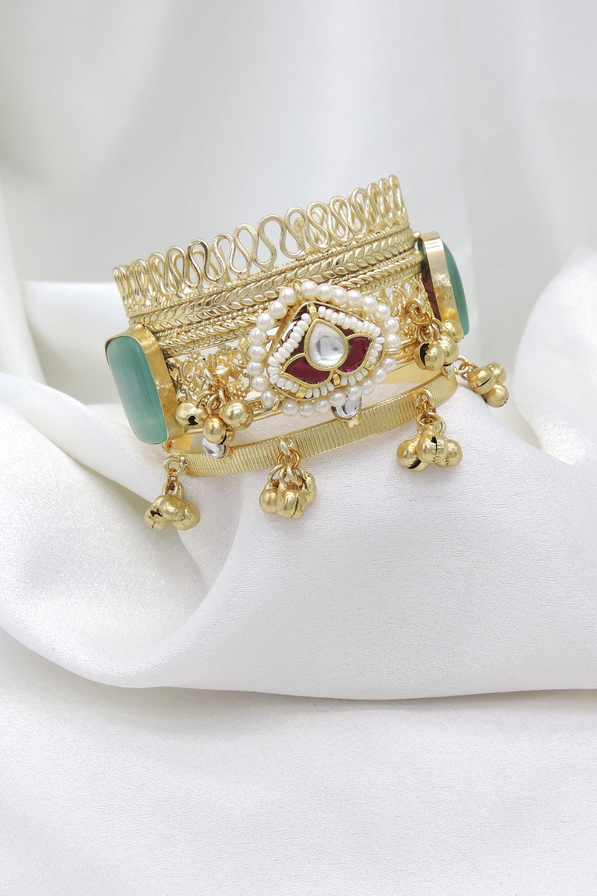 Gold-toned green stone pearl cuff bracelet with traditional detailing and dangling charms by joyrias