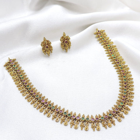 Ruby emerald traditional necklace set with intricate gold-tone motifs and matching stud earrings by joyrias