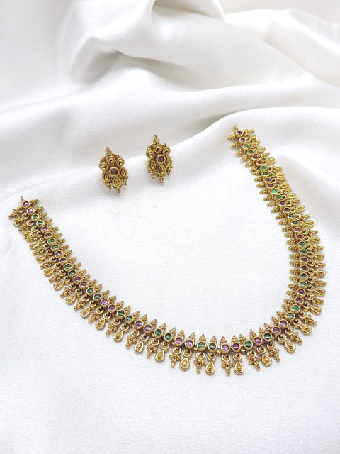 Ruby emerald traditional necklace set with intricate gold-tone motifs and matching stud earrings by joyrias