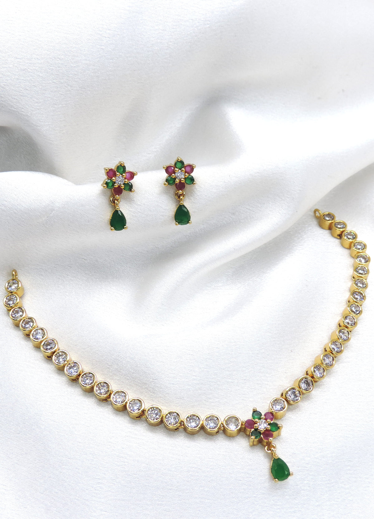 Gold-toned graduated tennis necklace with emerald floral pendant and matching drop earrings by joyrias
