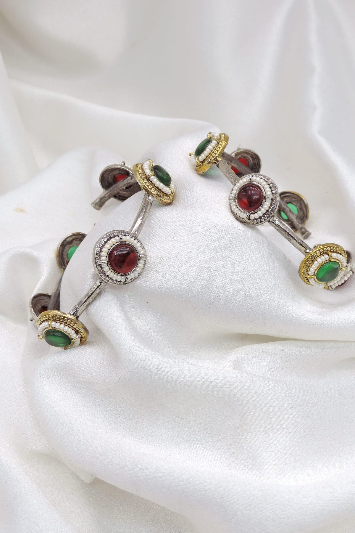 Oxidized dual-tone gold silver bangle set with green and red stone detailing by joyrias