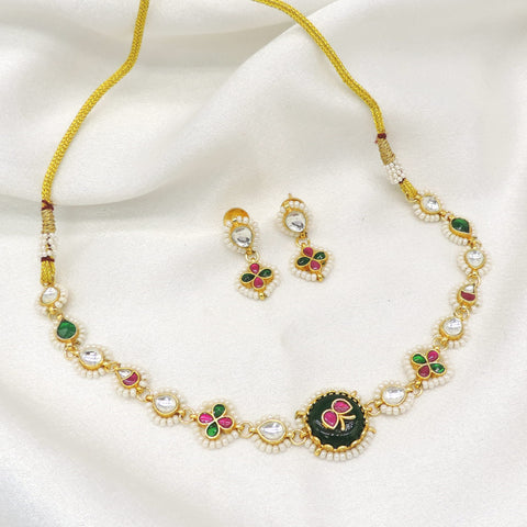 Gold-toned Meenakari floral Kundan necklace set with green pink accents and pearl detailing by joyrias