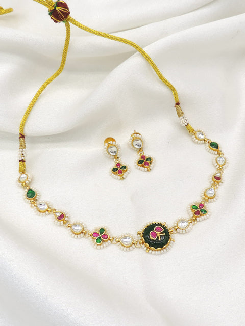 Gold-toned Meenakari floral Kundan necklace set with green pink accents and pearl detailing by joyrias
