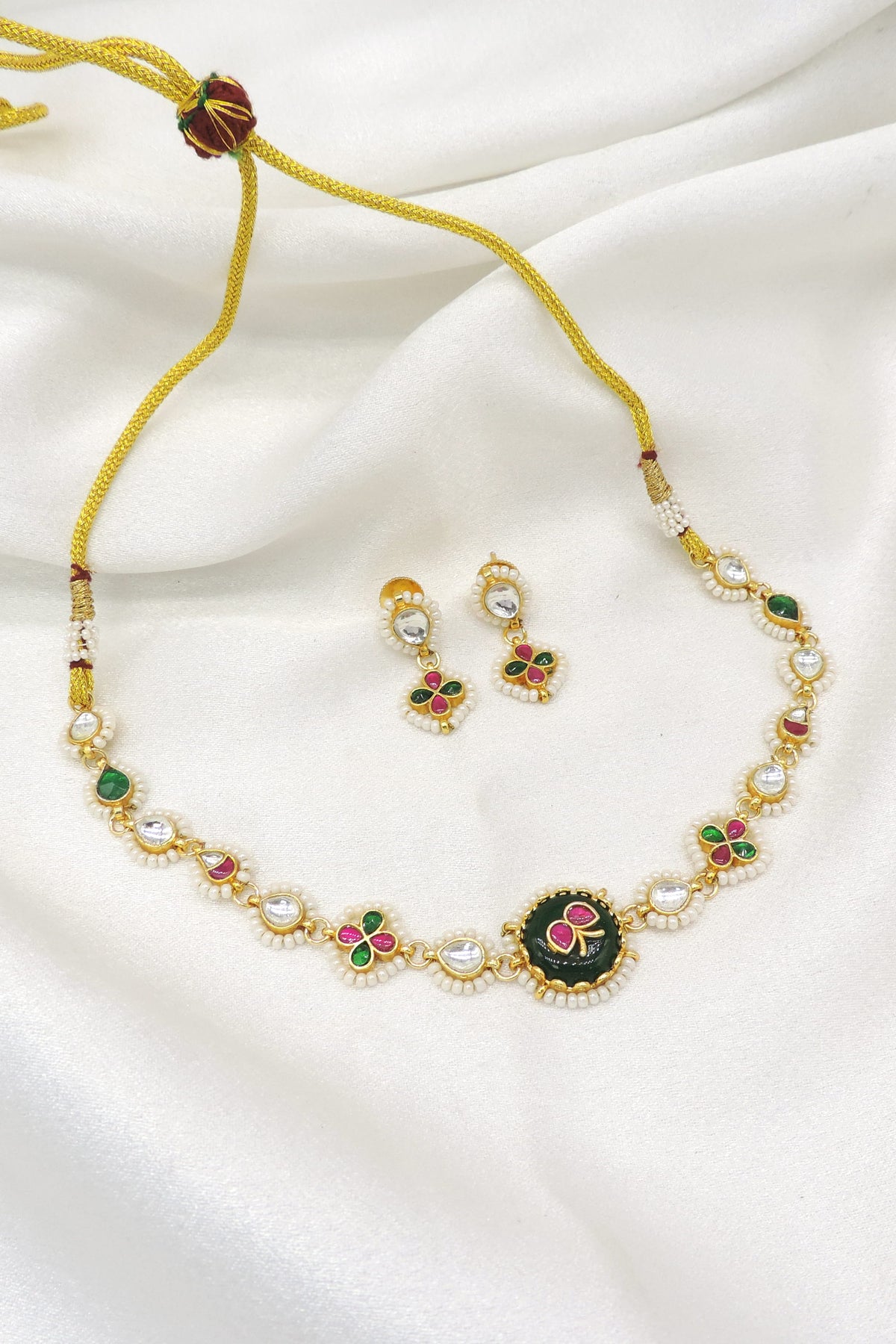 Gold-toned Meenakari floral Kundan necklace set with green pink accents and pearl detailing by joyrias