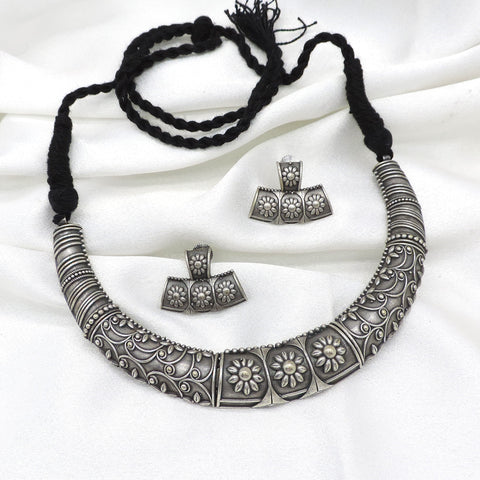 Oxidized floral carved silver Hasli necklace set with matching earrings by Joyrias