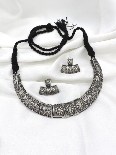 Oxidized floral carved silver Hasli necklace set with matching earrings by Joyrias