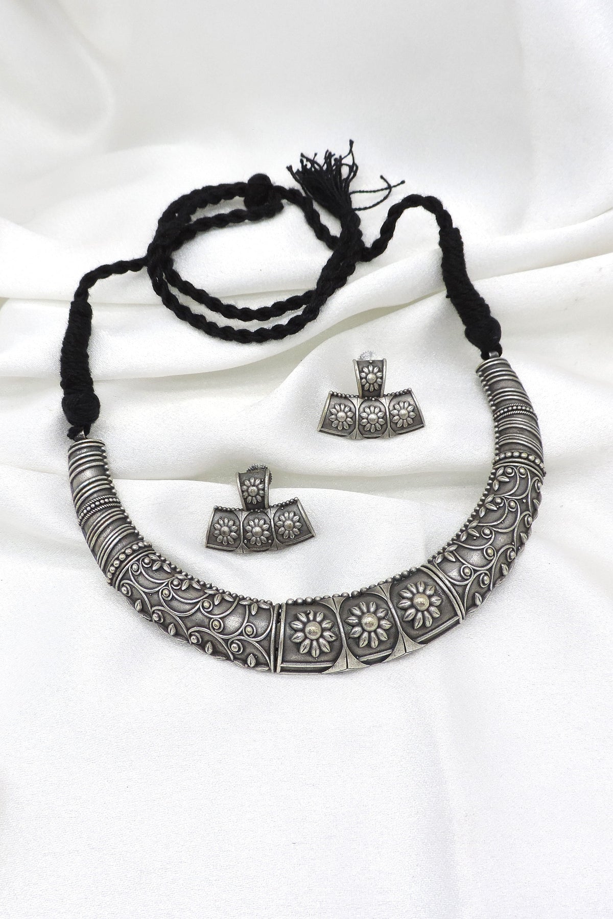 Oxidized floral carved silver Hasli necklace set with matching earrings by Joyrias