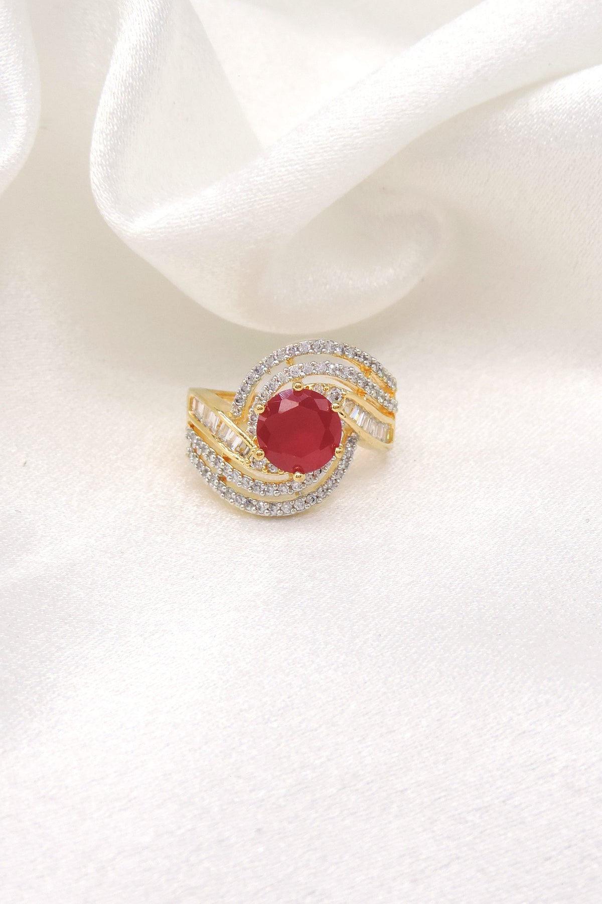 Crimson red stone CZ swirled ring with gold-toned detailing by joyrias