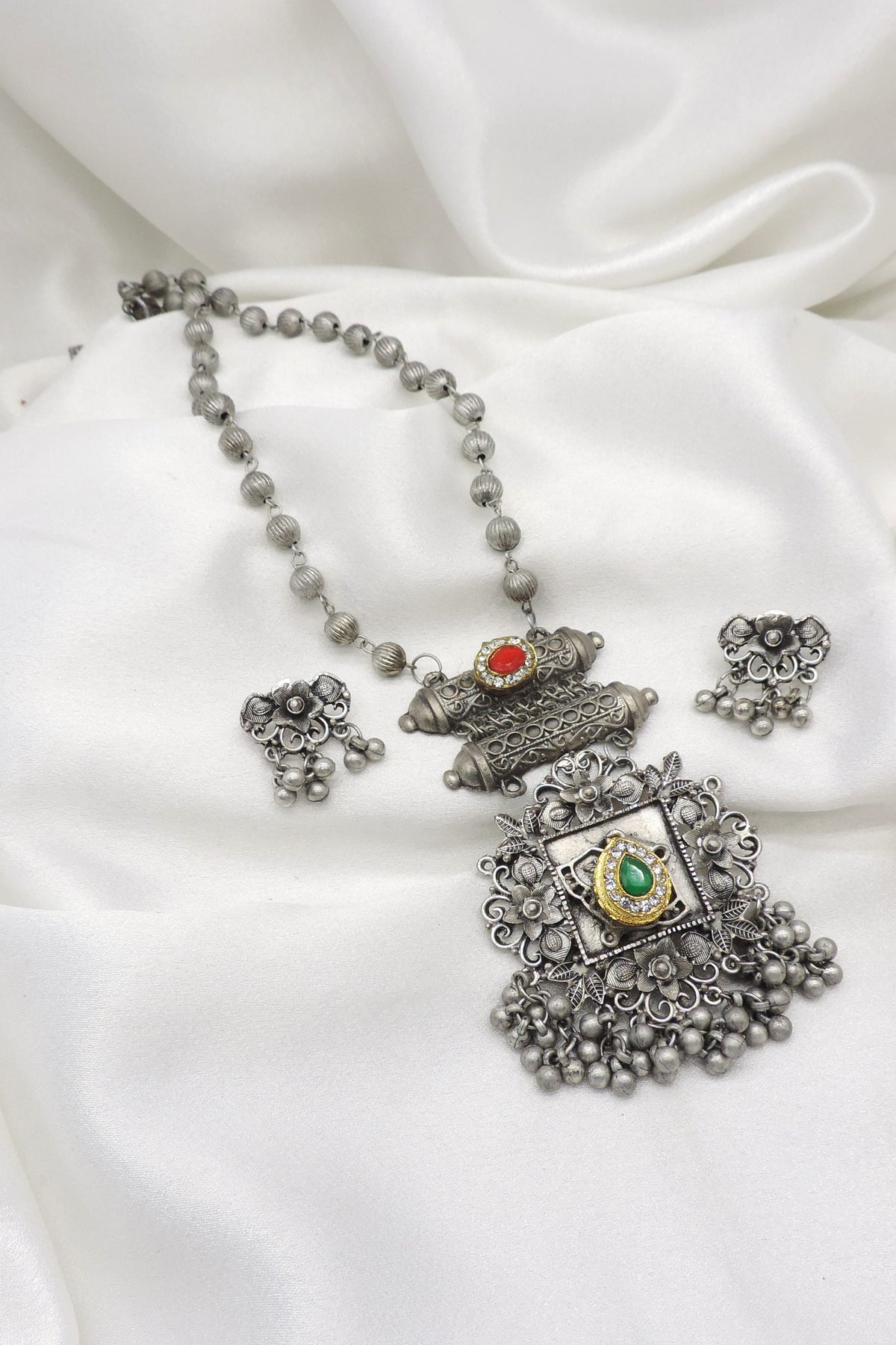 Oxidized floral green red stone pendant necklace set with matching earrings and hanging bead detailing by joyrias