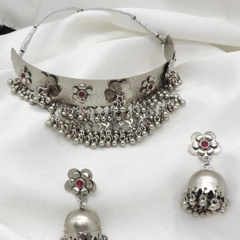 Oxidized silver floral ghungroo choker set with maroon stone accents and matching jhumka earrings by joyrias