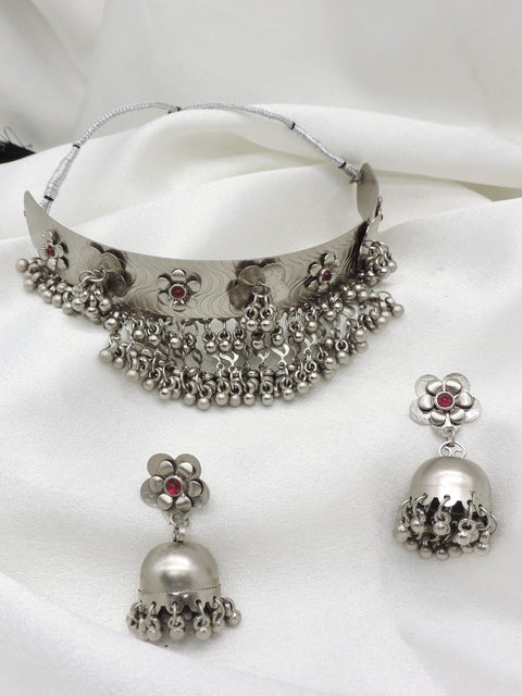 Oxidized silver floral ghungroo choker set with maroon stone accents and matching jhumka earrings by joyrias