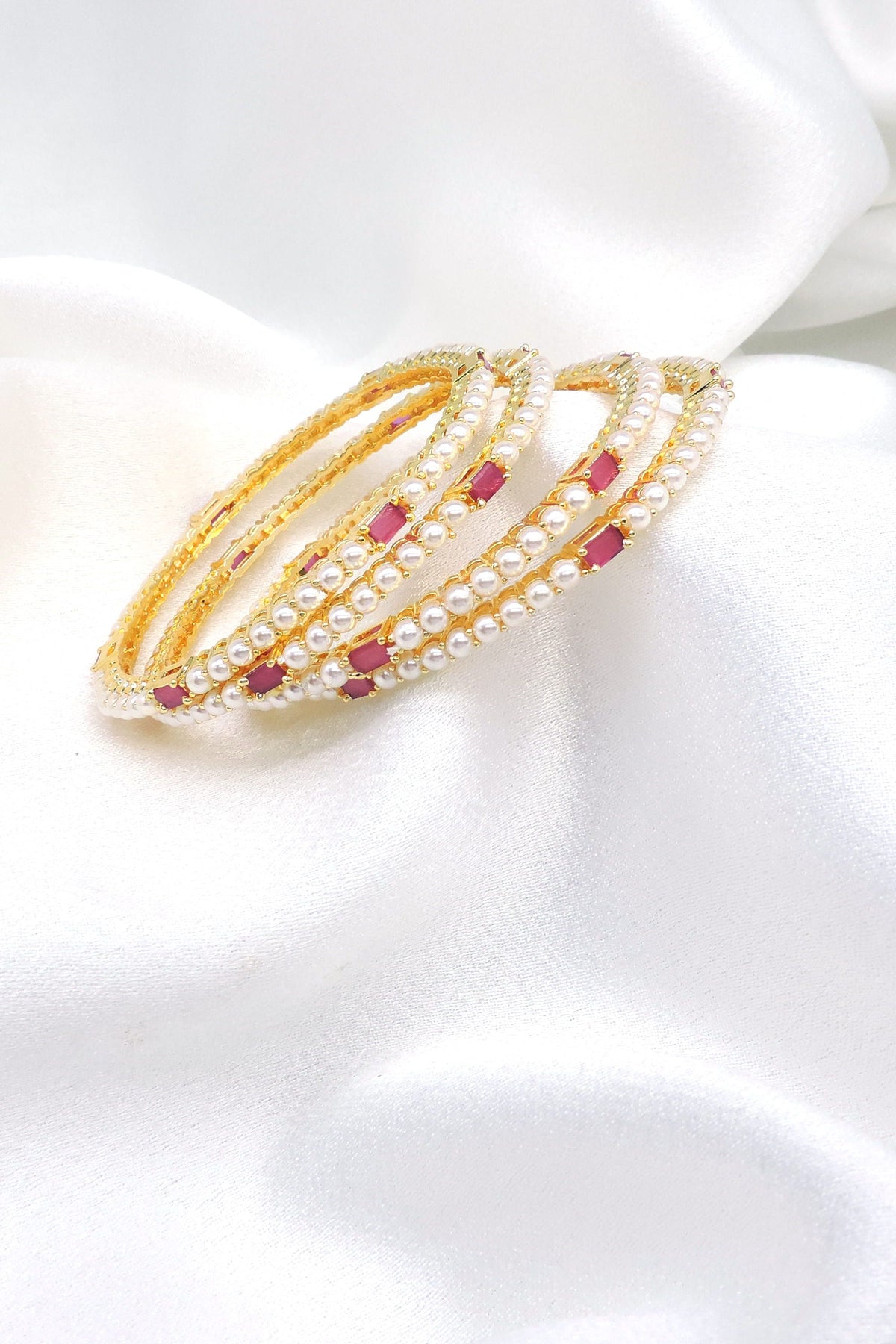 Gold-toned pink stone pearl AD bangle set with delicate pearl detailing by joyrias