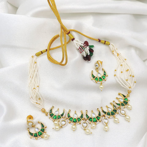 Green kundan crescent pearl choker set with matching earrings by Joyrias