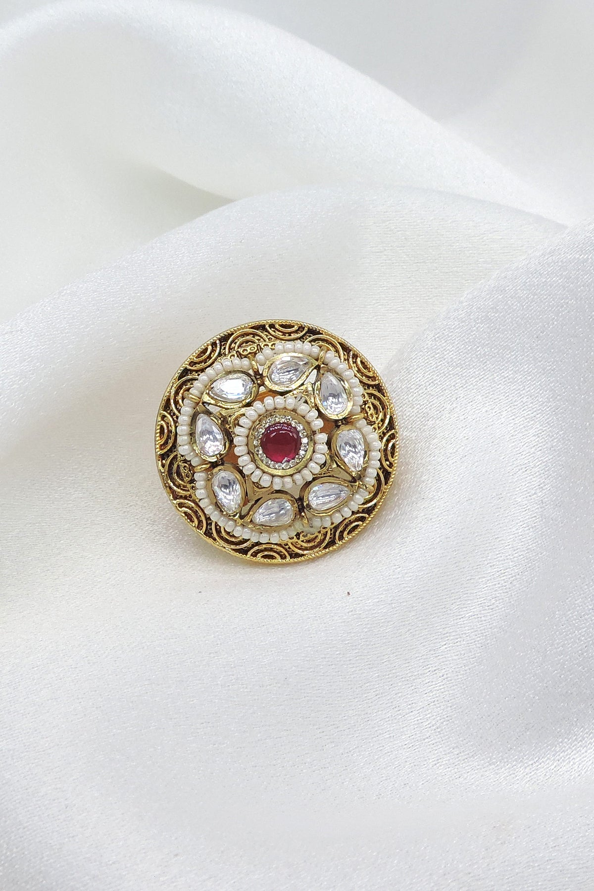 Temple ornate kundan polki ring with red center stone and pearl detailing by joyrias