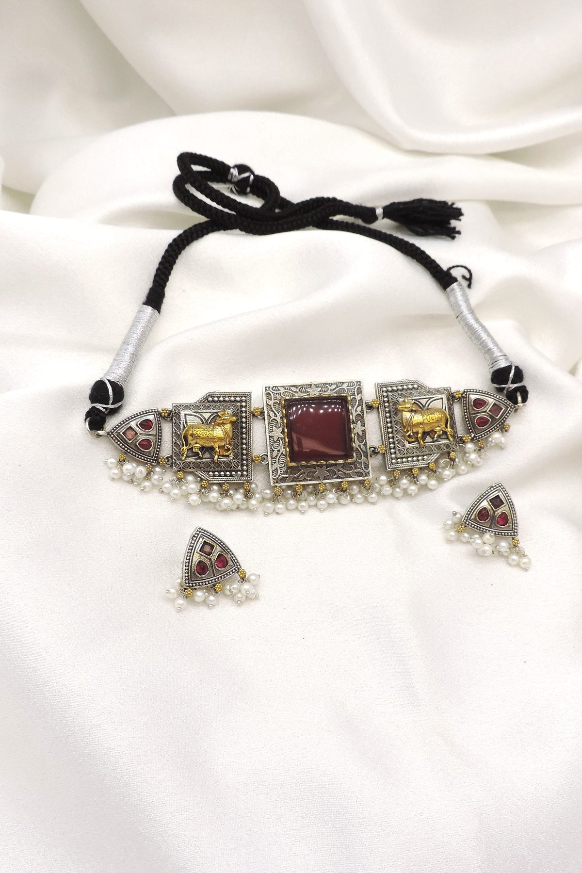 Oxidized dual-tone elephant pearl choker set with maroon stone detailing and matching earrings by joyrias
