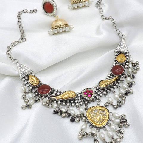 Oxidized dual-tone maroon polki choker set with pearl detailing and matching jhumka earrings by joyrias