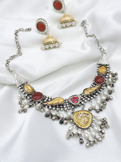 Oxidized dual-tone maroon polki choker set with pearl detailing and matching jhumka earrings by joyrias
