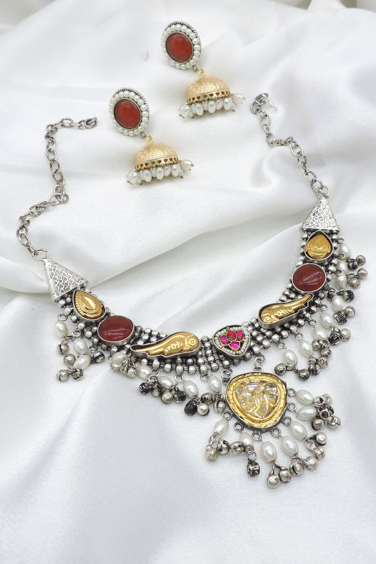 Oxidized dual-tone maroon polki choker set with pearl detailing and matching jhumka earrings by joyrias