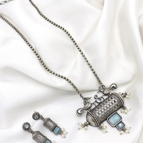 Oxidized peacock carved pendant necklace set with pearl detailing and matching earrings by joyrias