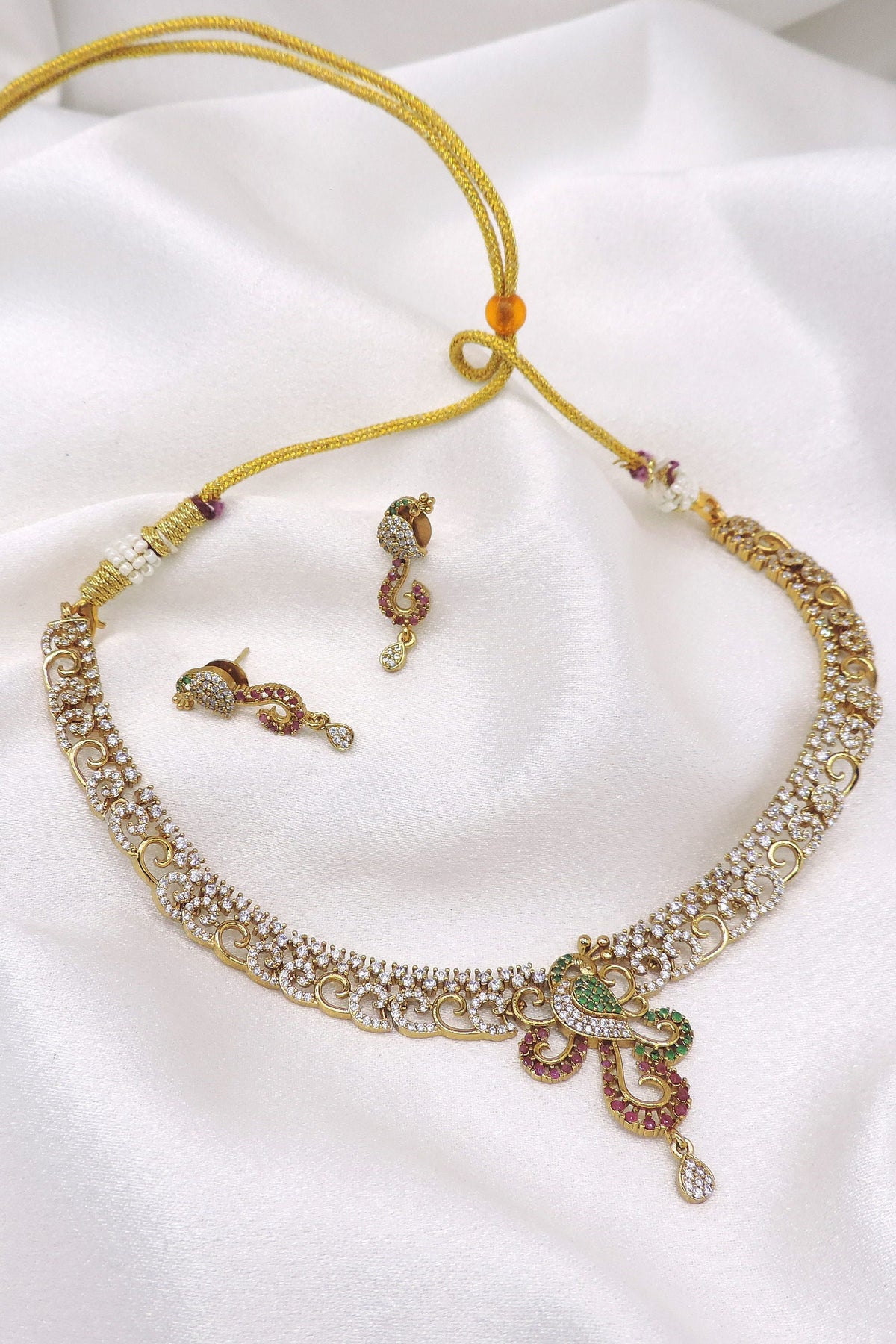 Gold-toned peacock CZ necklace set with green and maroon detailing and matching earrings by joyrias