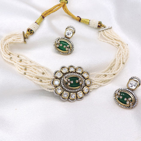 Multi-strand pearl kundan choker necklace set with green detailing, matching earrings and maang tikka by joyrias