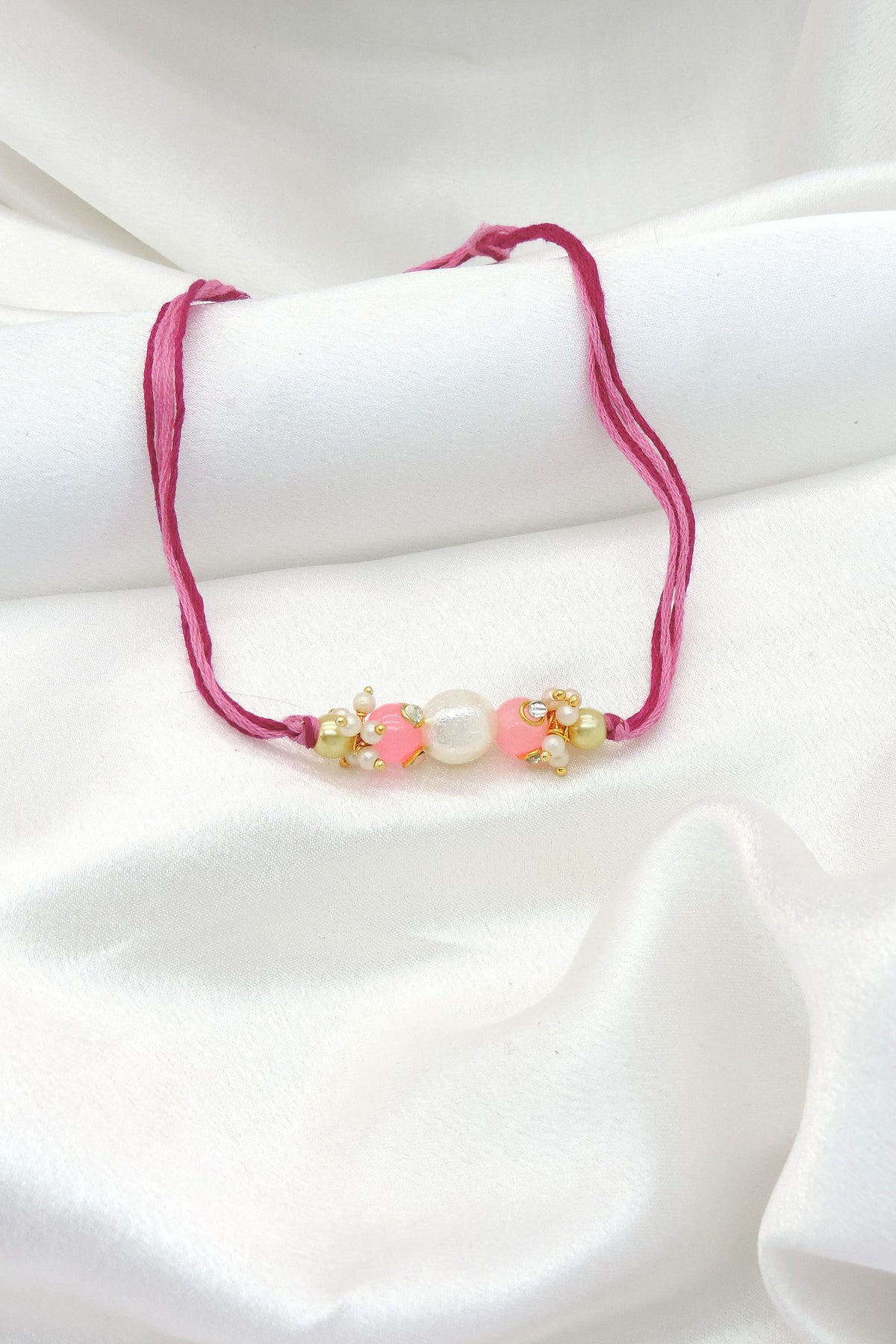 Pearl pink bead bhaiya rakhi with freshwater pearl and seed pearl clusters by Joyrias
