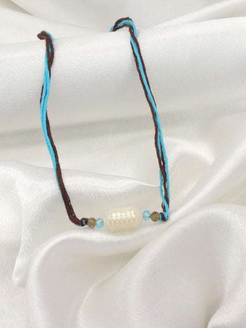 Pearl bead minimal bhaiya rakhi with turquoise and smoky brown beads on dual toned thread by Joyrias