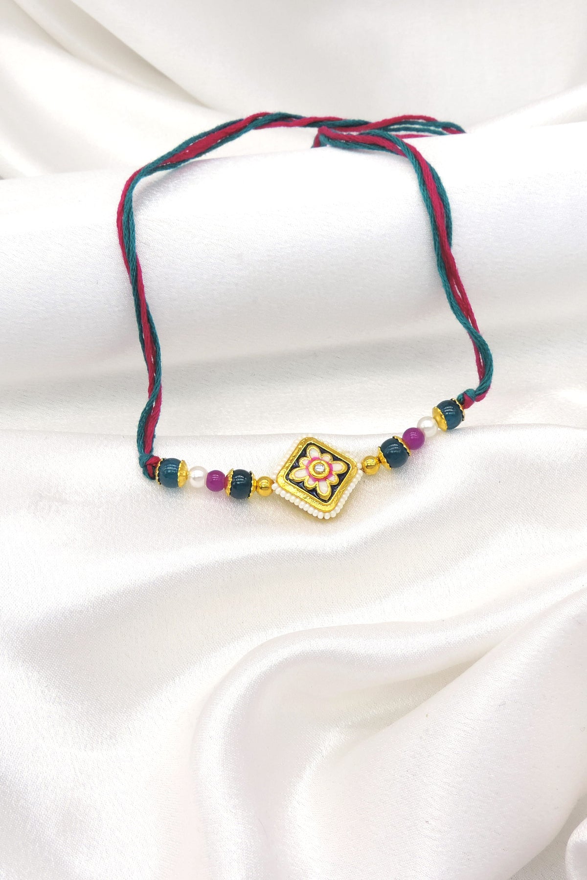 Meenakari square floral bhaiya rakhi with kundan accent and seed pearl border on teal magenta thread by Joyrias