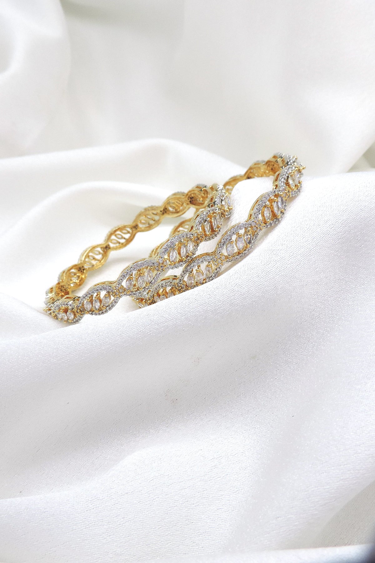 Elegant gold-toned silver AD bangle set with intricate intertwined stone detailing by joyrias