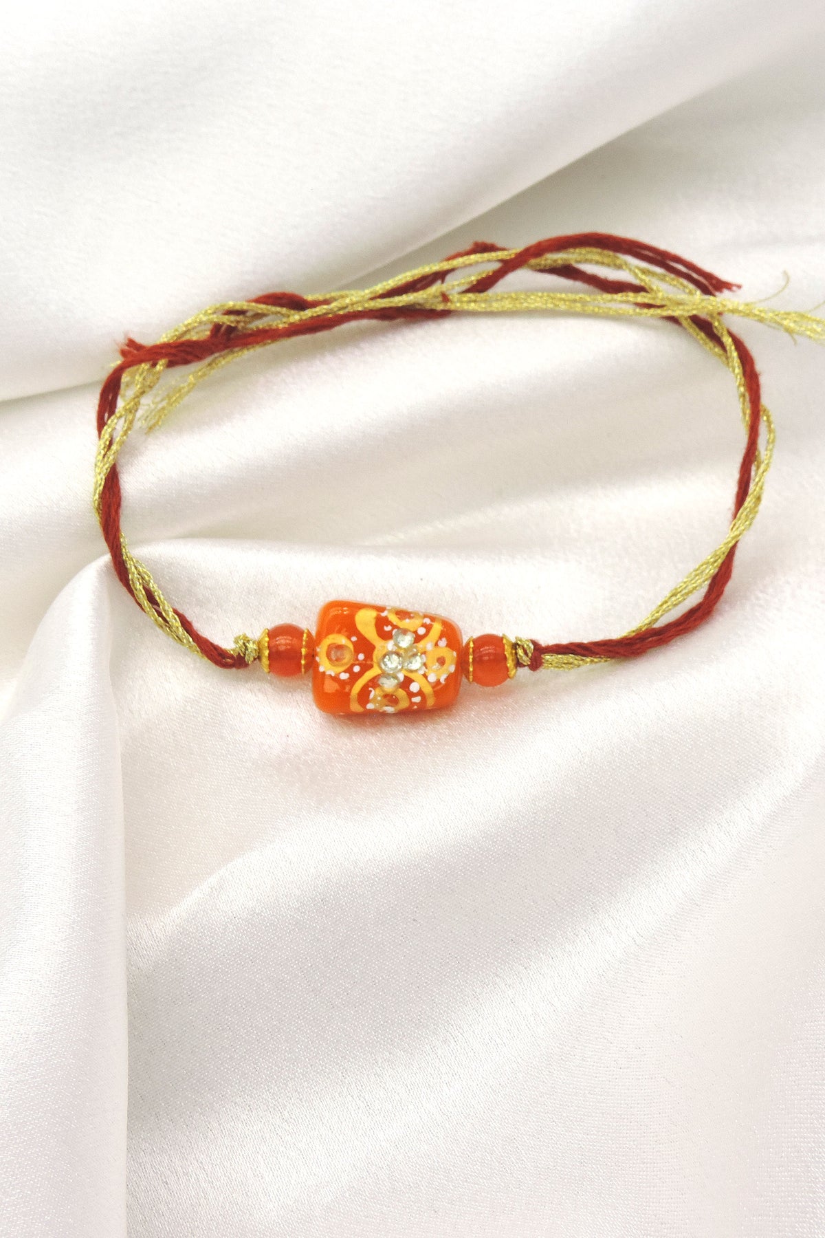 Handcrafted Orange Bead Rakhi with Crystal Floral Design