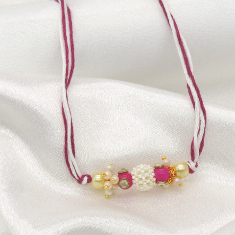 Pearl cluster bhaiya rakhi with kundan accent and pink stone on magenta white thread by Joyrias