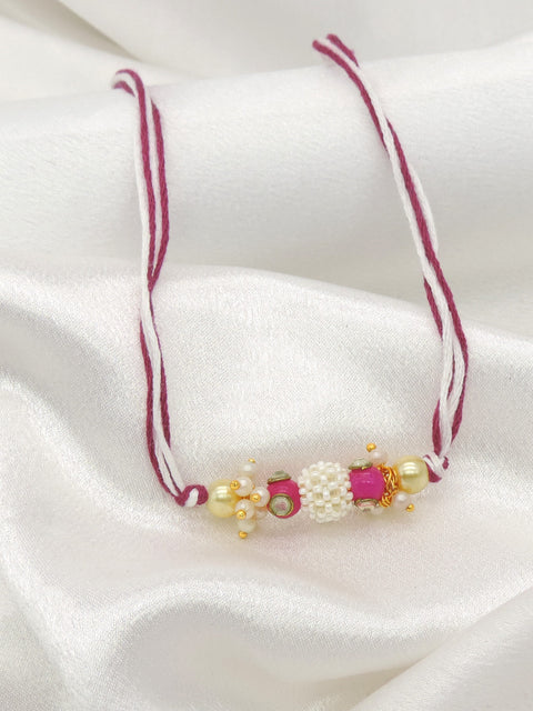 Pearl cluster bhaiya rakhi with kundan accent and pink stone on magenta white thread by Joyrias