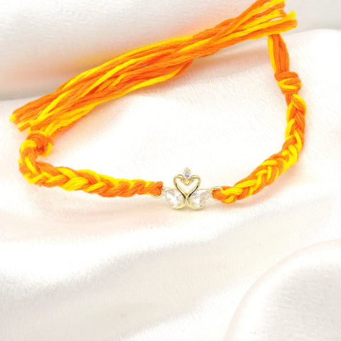 CZ swan bhaiya rakhi with gold swan duo charm and CZ teardrop wings on braided yellow orange thread by Joyrias