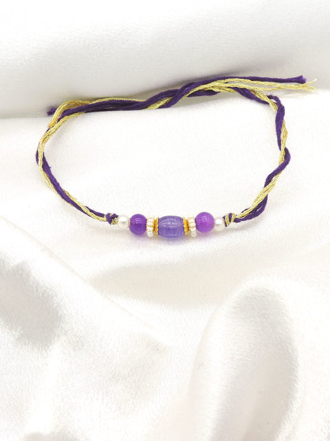 Purple bead bhaiya rakhi with lavender oval centerpiece and gold spacers on purple gold thread by Joyrias