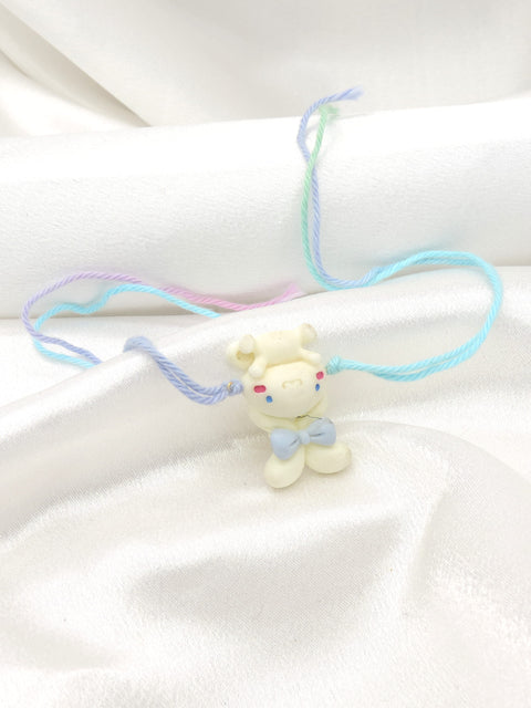 Teddy bear kids rakhi with 3D white bear charm and blue bow on pastel multicolor thread by Joyrias