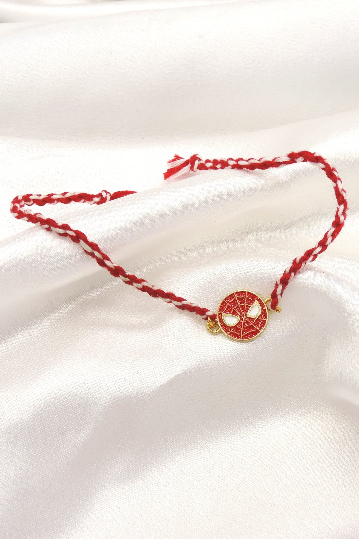Spiderman kids rakhi with red enamel mask disc charm on braided red and white thread by Joyrias