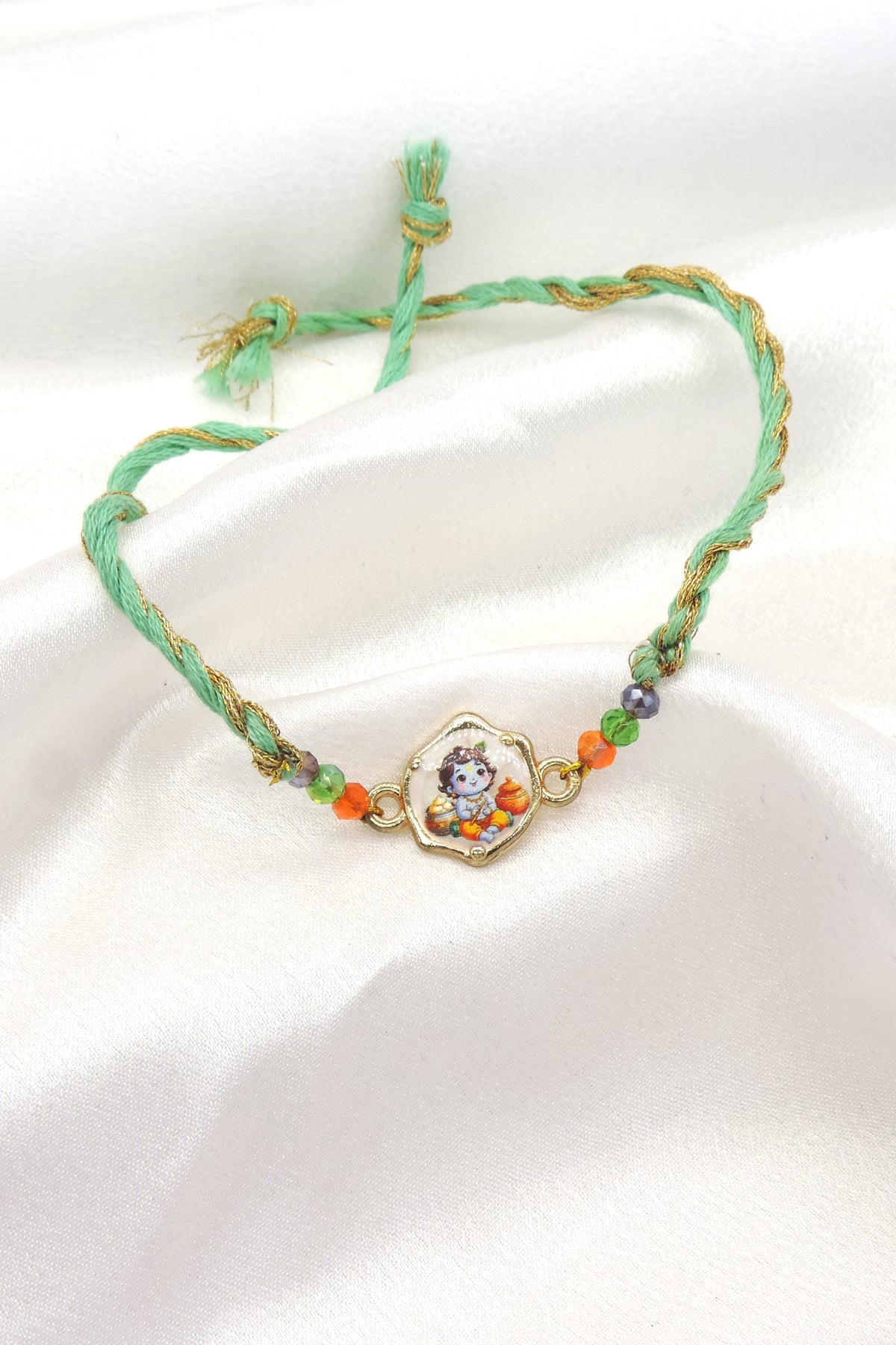 Bal Gopal Krishna bhaiya rakhi with printed Baby Krishna charm and faceted beads on mint green gold thread by Joyrias