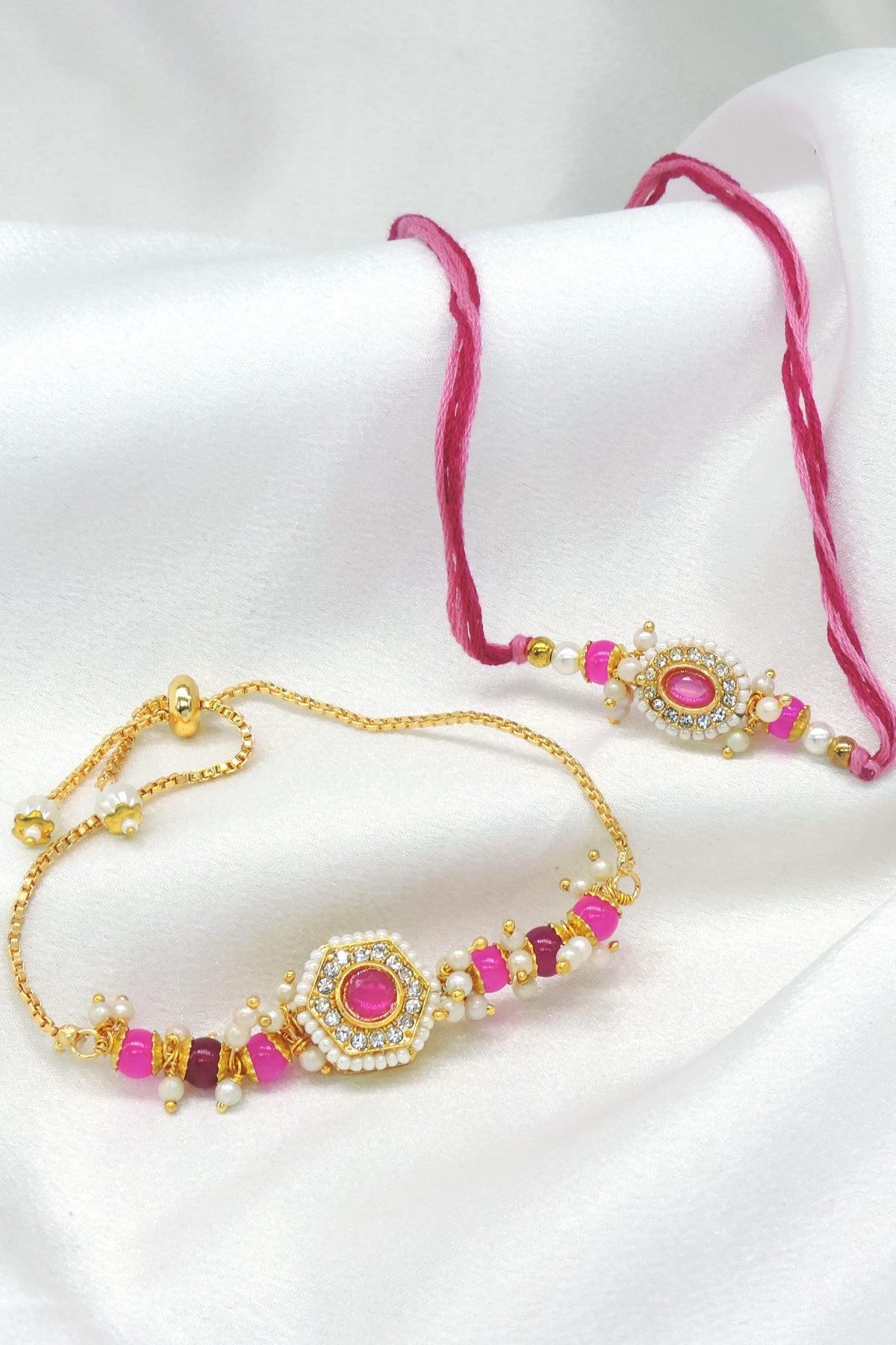 CZ halo pink bhaiya bhabhi rakhi set with seed pearl border and pearl cluster drops by Joyrias