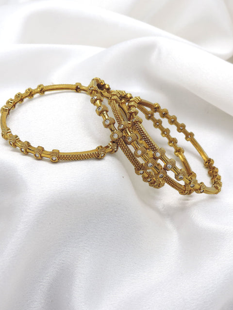 Elegant gold-toned AD detailed bangle set with intricate traditional patterns by joyrias