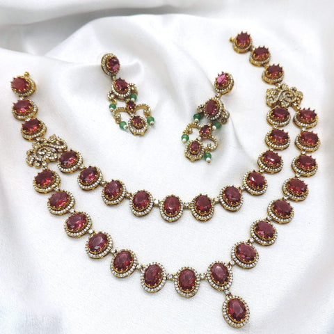 Maroon kundan layered jewelry set with pearl details and matching earrings by joyrias