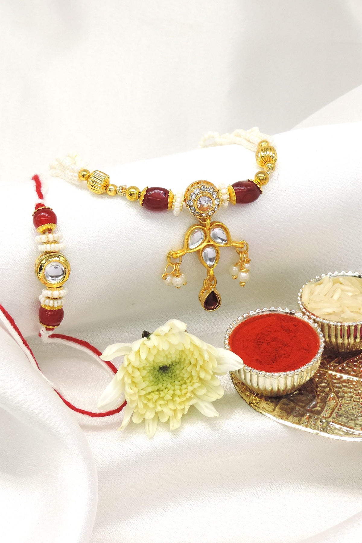 Kundan drop bhaiya bhabhi rakhi set with CZ halo and pearl accents by Joyrias
