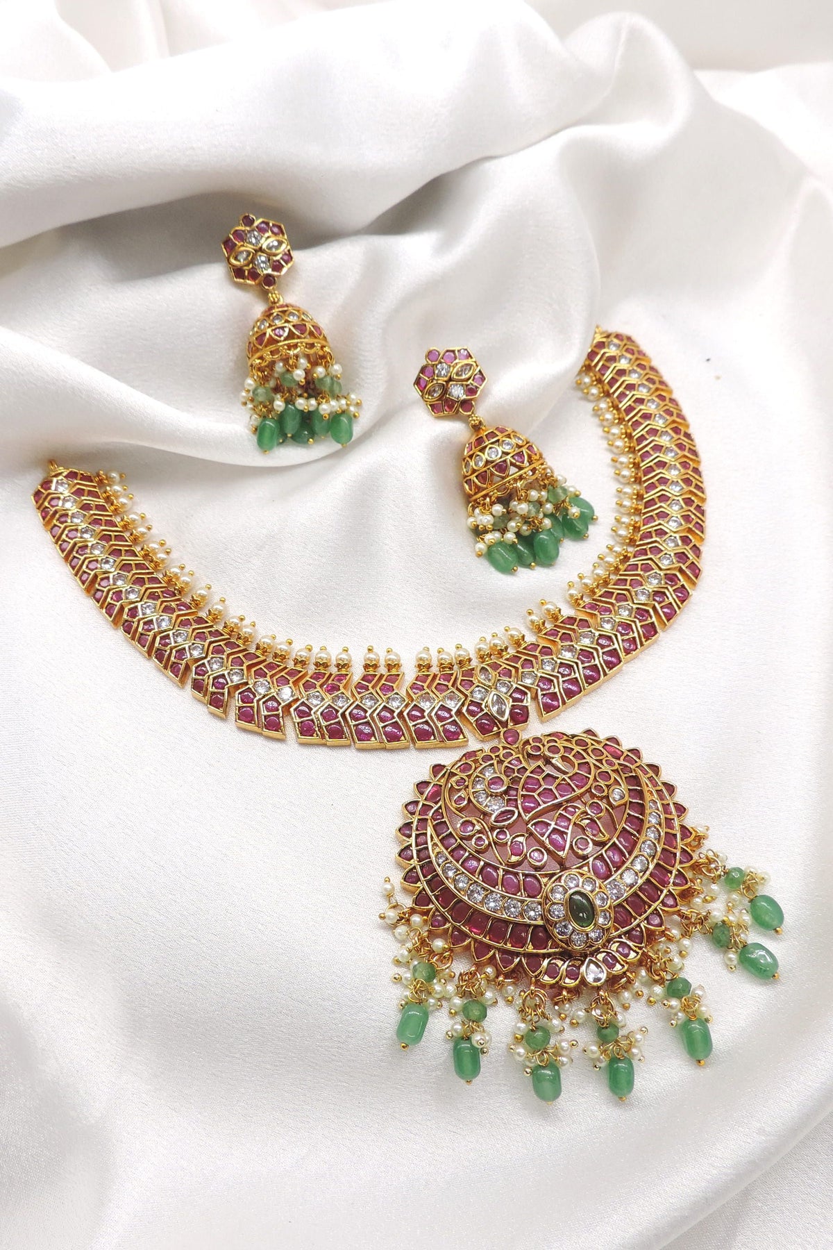 Temple royal gold-toned maroon green kundan necklace set with pearl detailing and matching jhumka earrings by joyrias