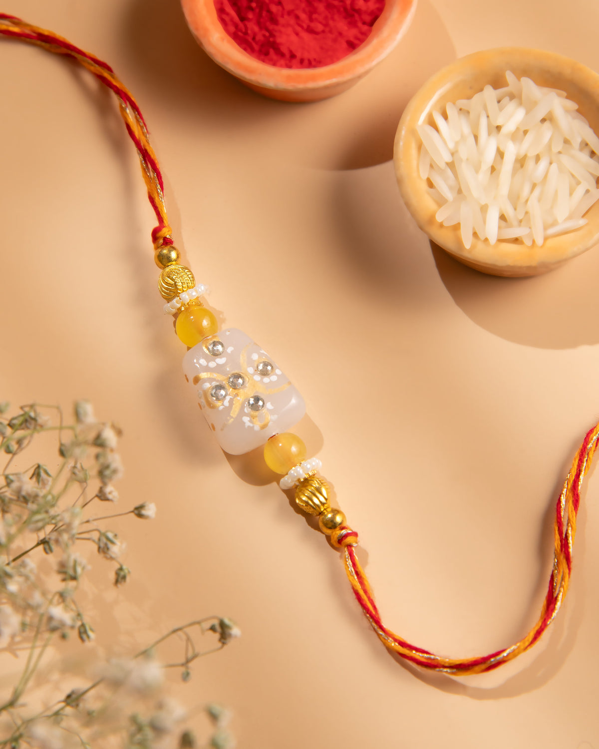 Handcrafted Orange Bead Rakhi with Crystal Floral Design